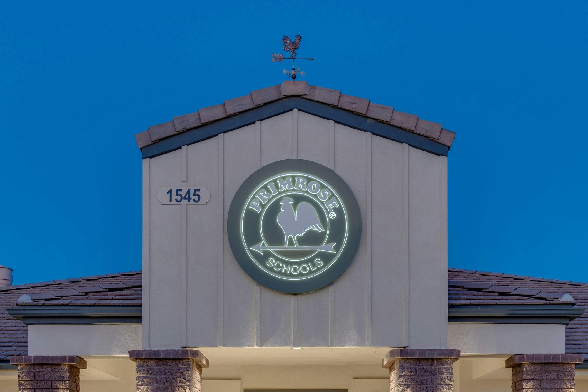 Building facade with a circular sign that reads "Primrose Schools"