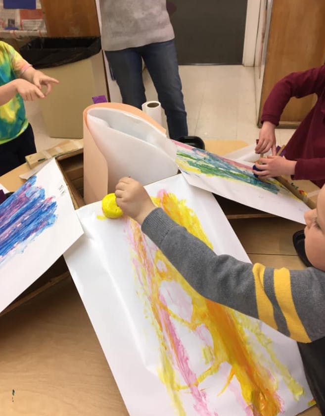 Child painting with a sponge on paper