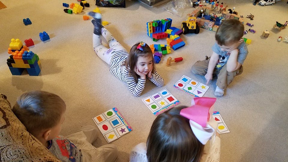 Children playing with toys and cards on the floor