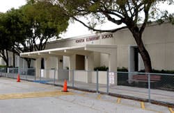 Exterior of a school building with trees and a covered walkway