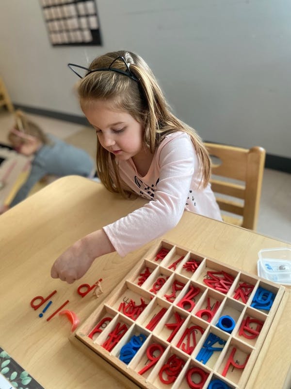Child playing with letter manipulatives at a table