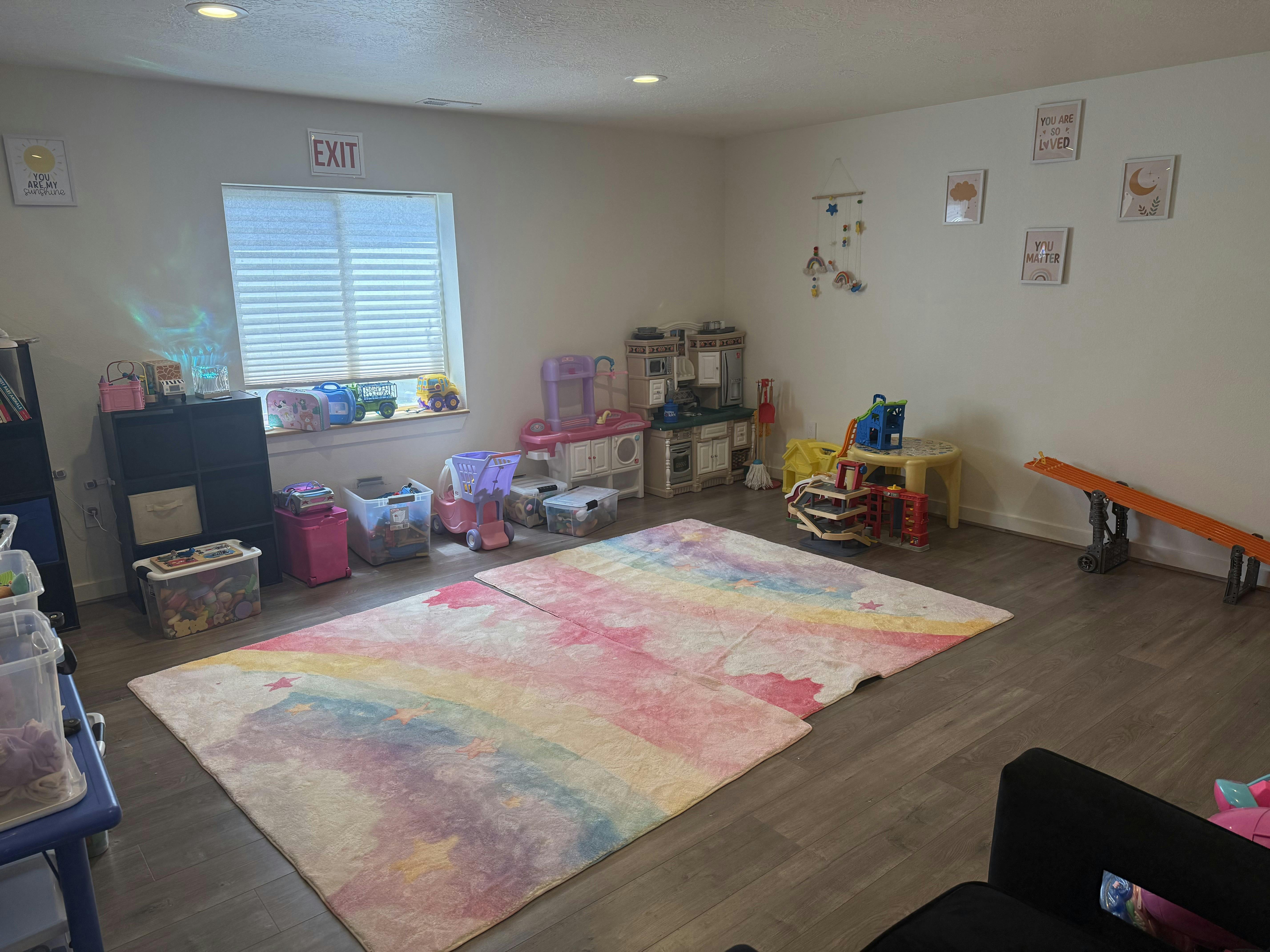 Children's playroom with various toys and a pastel star-patterned area rug