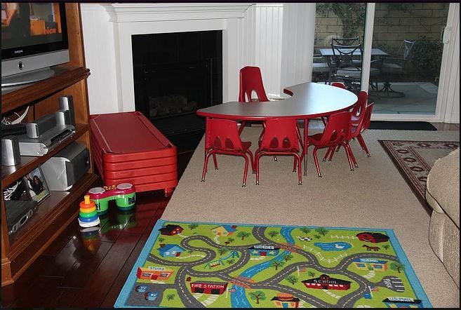 Children's play area with a red table and chairs, and a road map rug