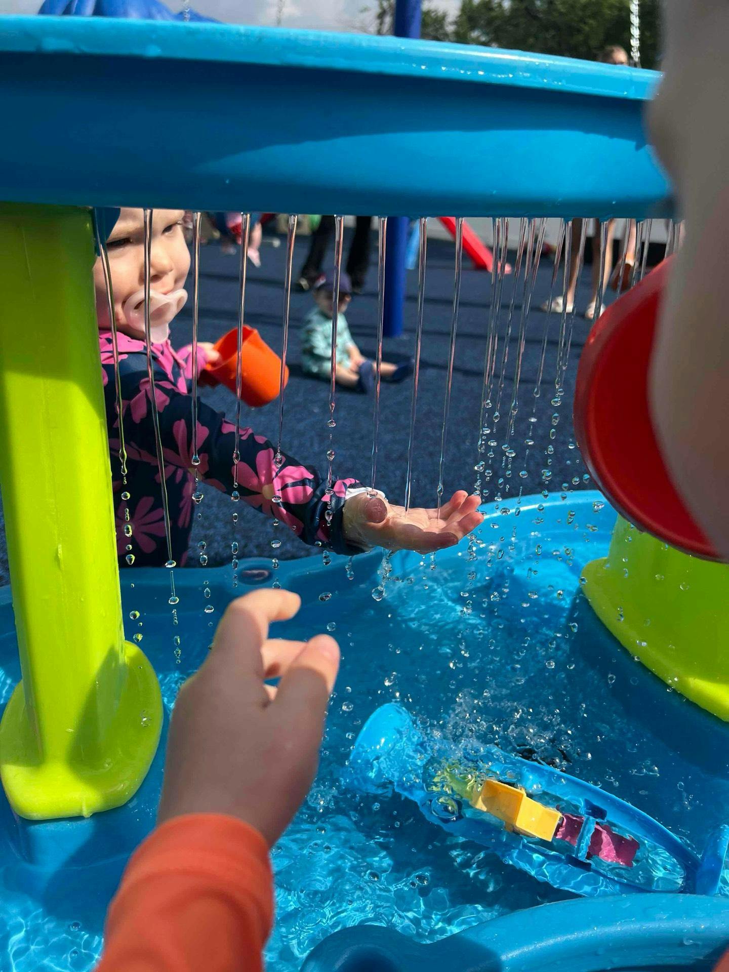 Child playing with water at a splash pad