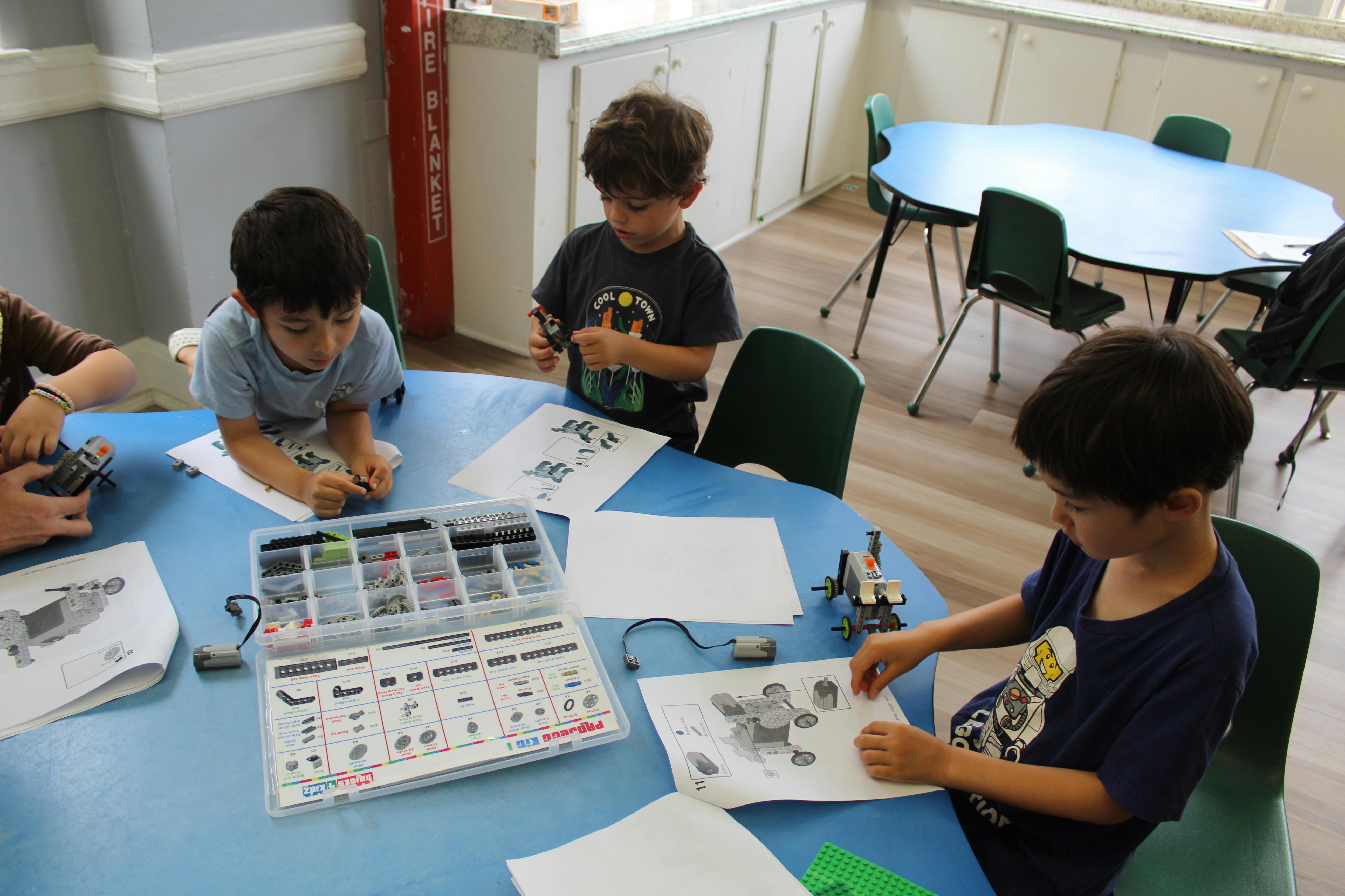 Children working on projects at a table in a classroom