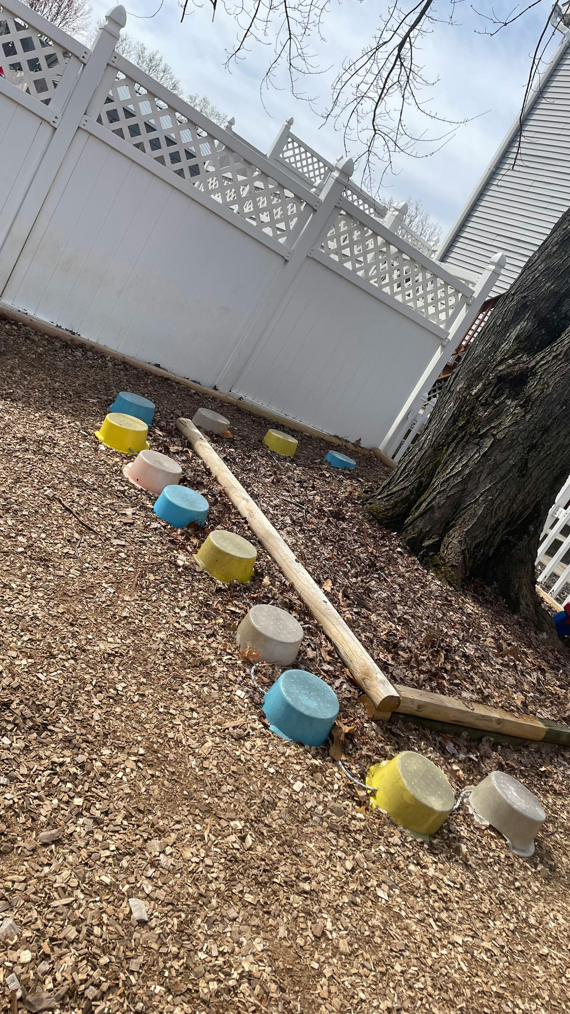 Colorful plastic bowls and a wooden beam on wood chips