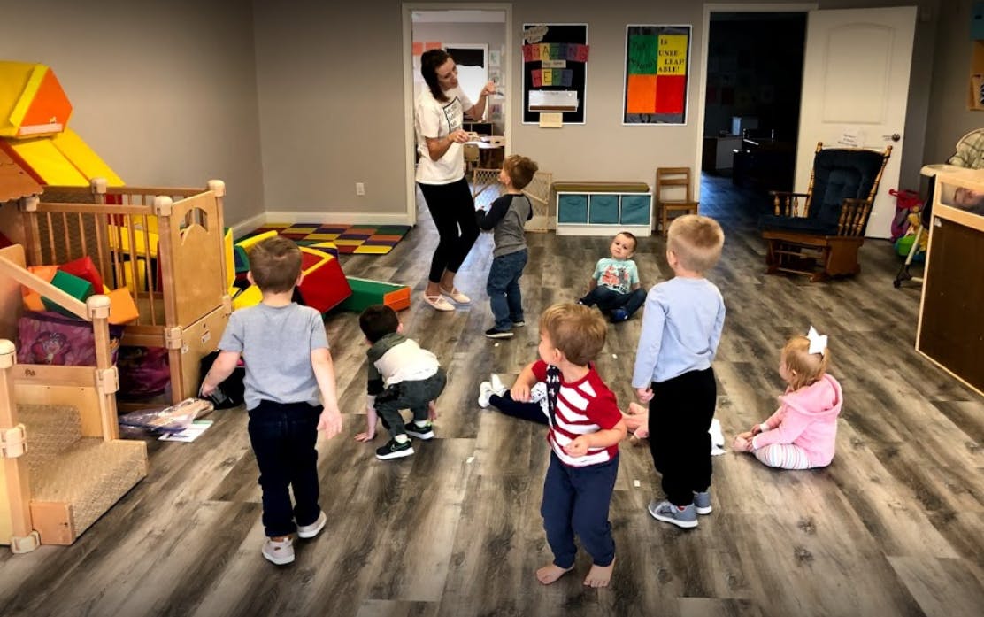 Adult interacting with children in a classroom