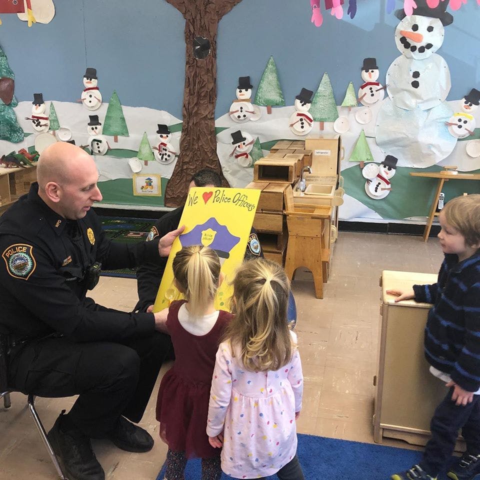 Police officer showing a sign to children in a classroom