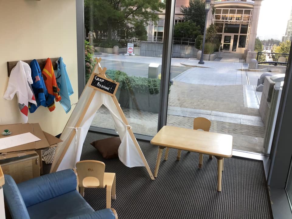 Play area with a teepee, small table and chairs, and a blue couch