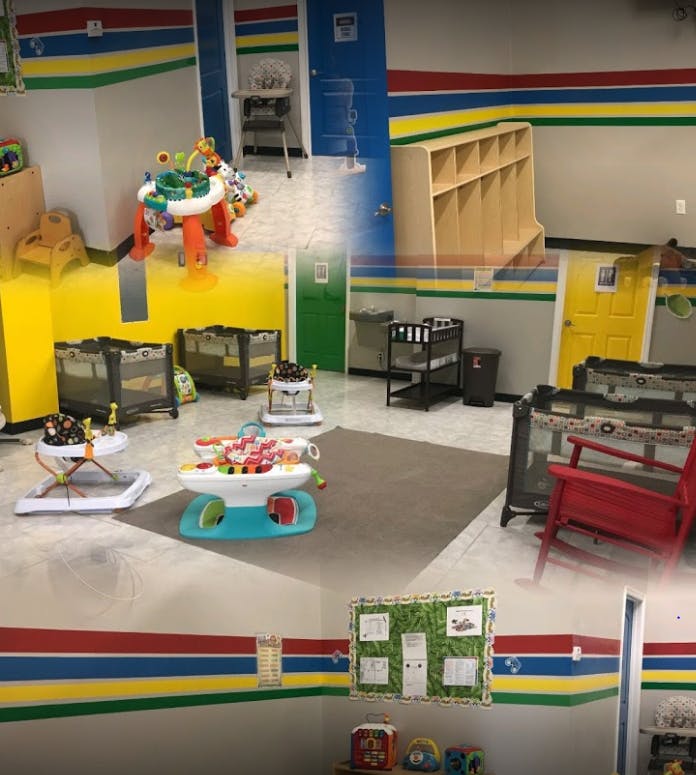 Childcare room with cribs, play mats, and various infant toys