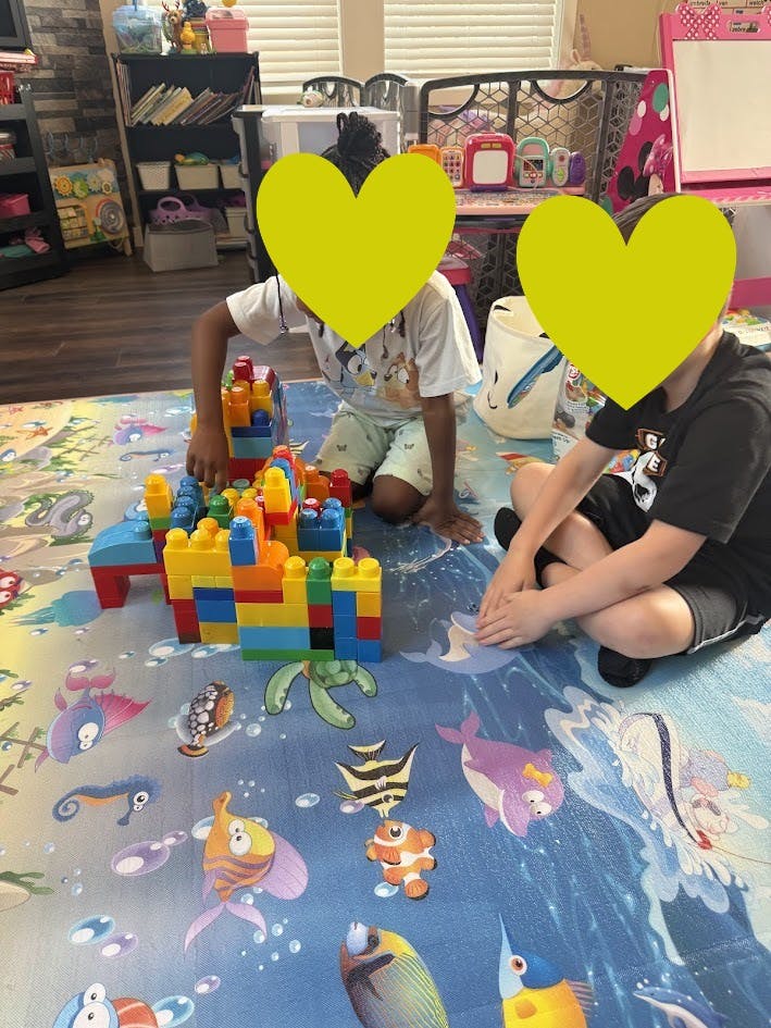 Two children playing with colorful building blocks on a mat