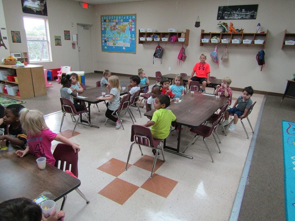Children sitting at tables in a classroom