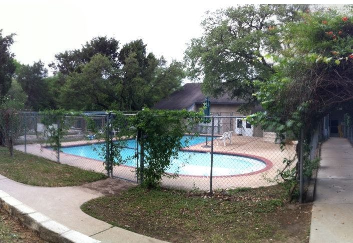 Fenced swimming pool area with a building in the background
