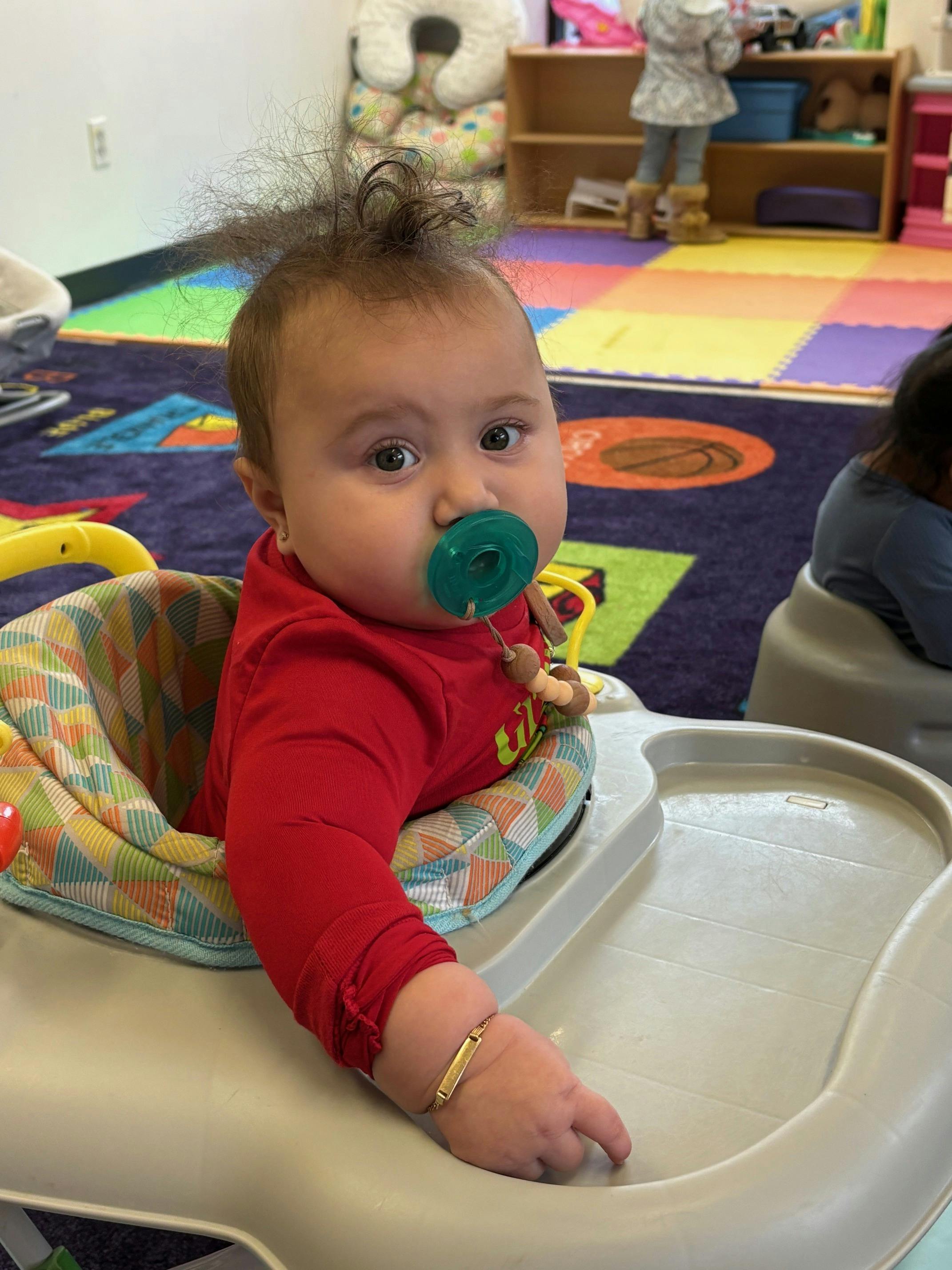 Child with pacifier in a high chair