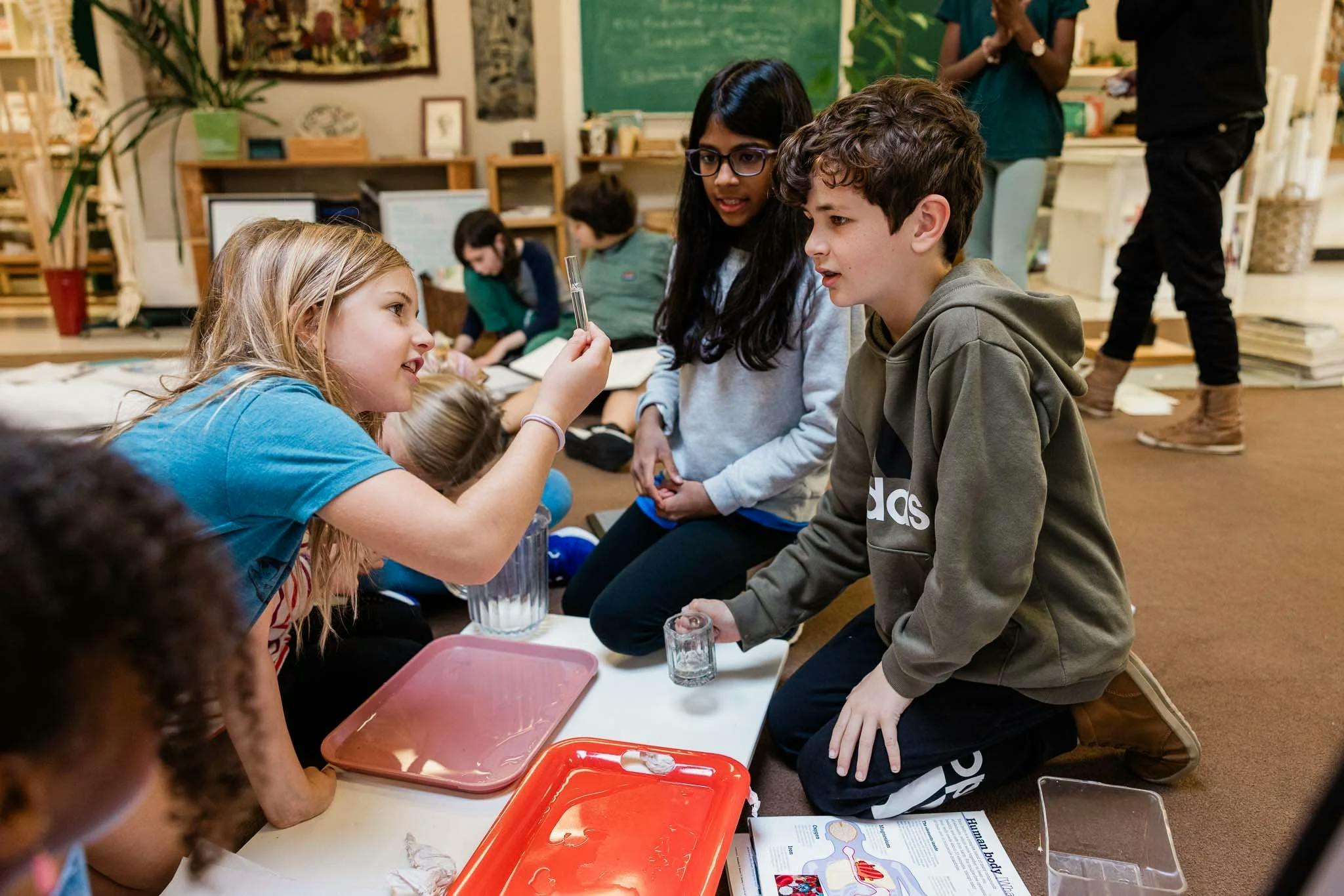 Three children engaging in a science experiment in a classroom