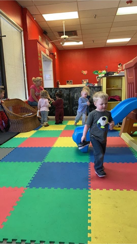 Adult and children in a room with colorful floor tiles