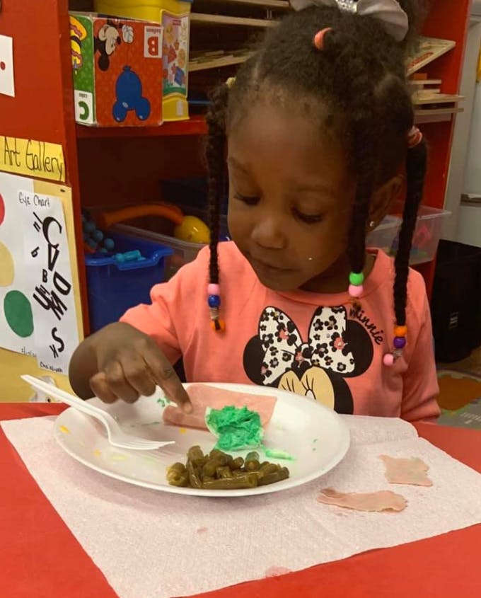 Child pointing at food on a plate