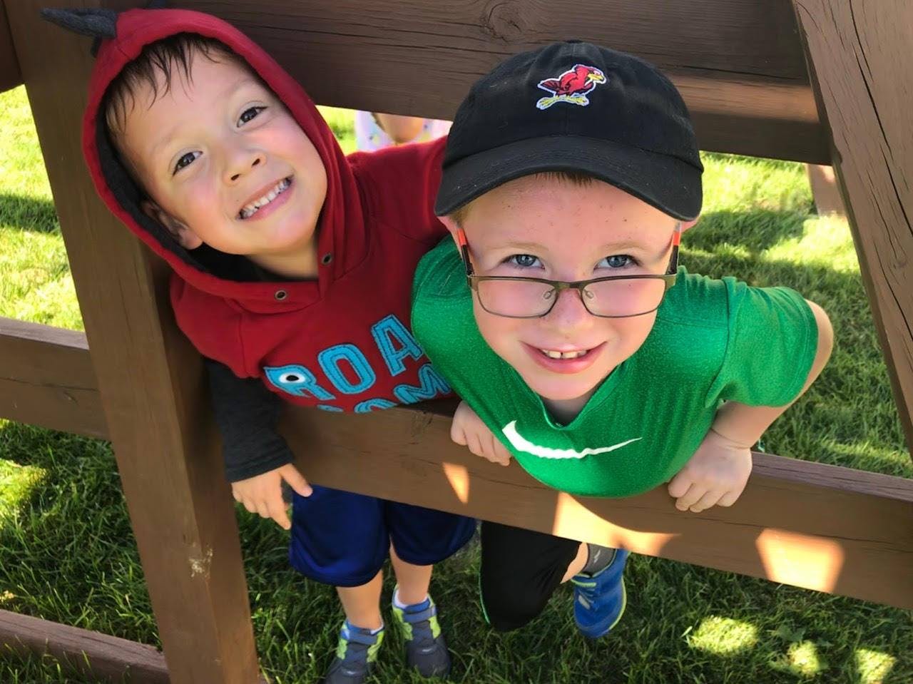 Two children looking up through wooden beams