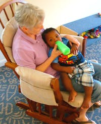 Person holding a child who is drinking from a bottle