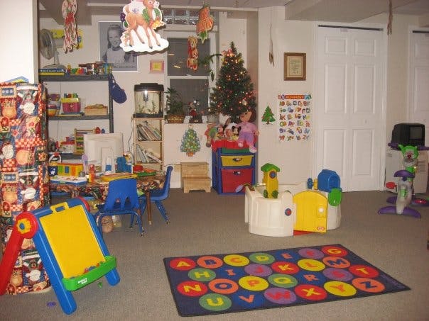 Playroom with toys, small tables and chairs, and an alphabet rug