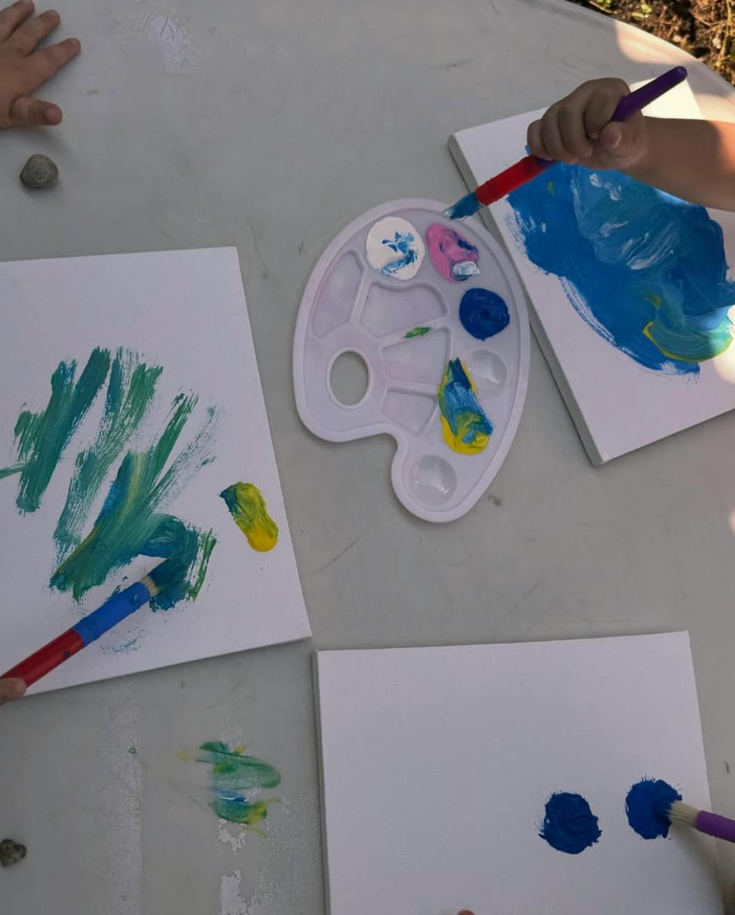 Children painting with brushes and paint on paper