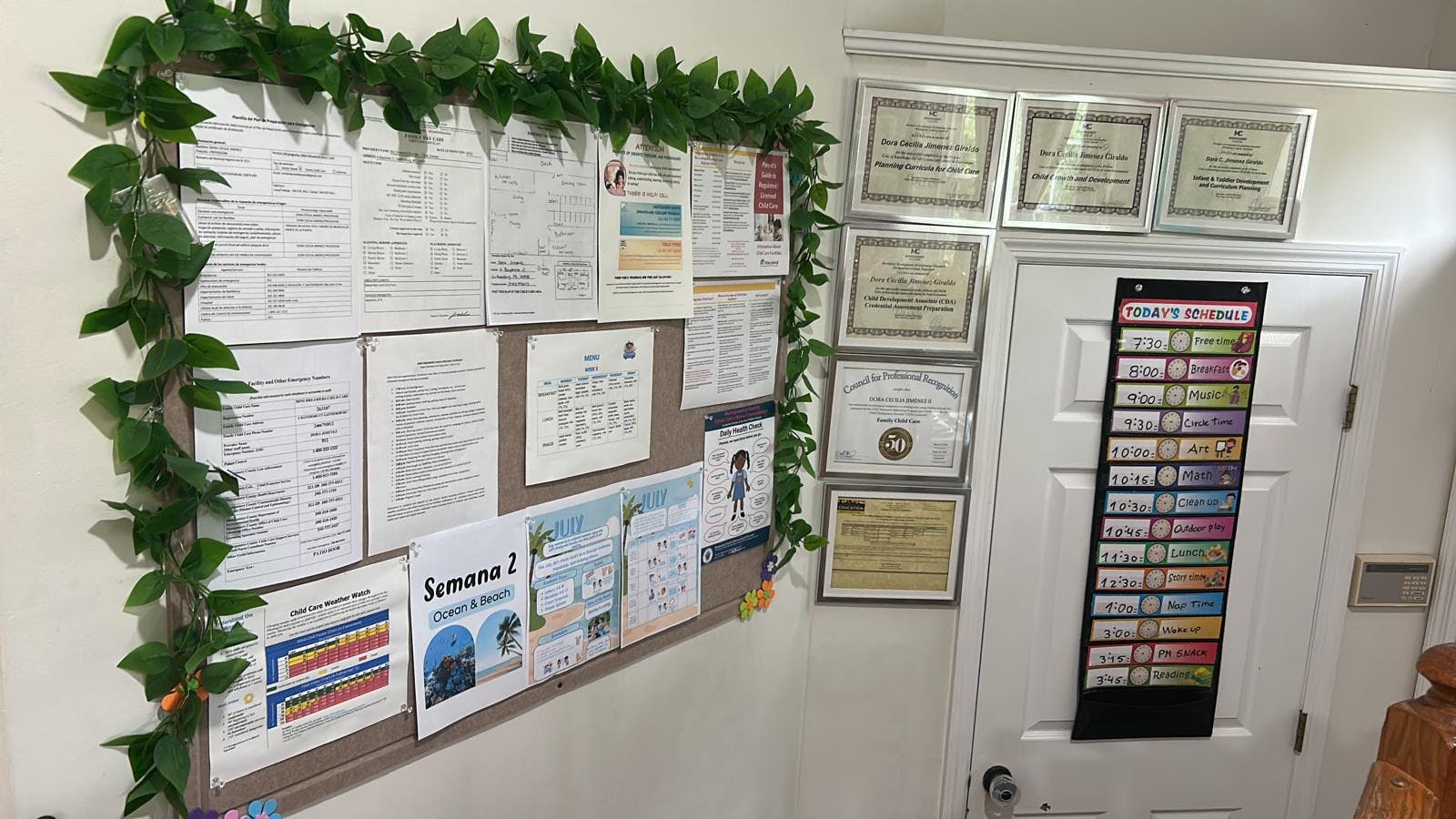 Child care bulletin board with documents and a daily schedule hanging on a door