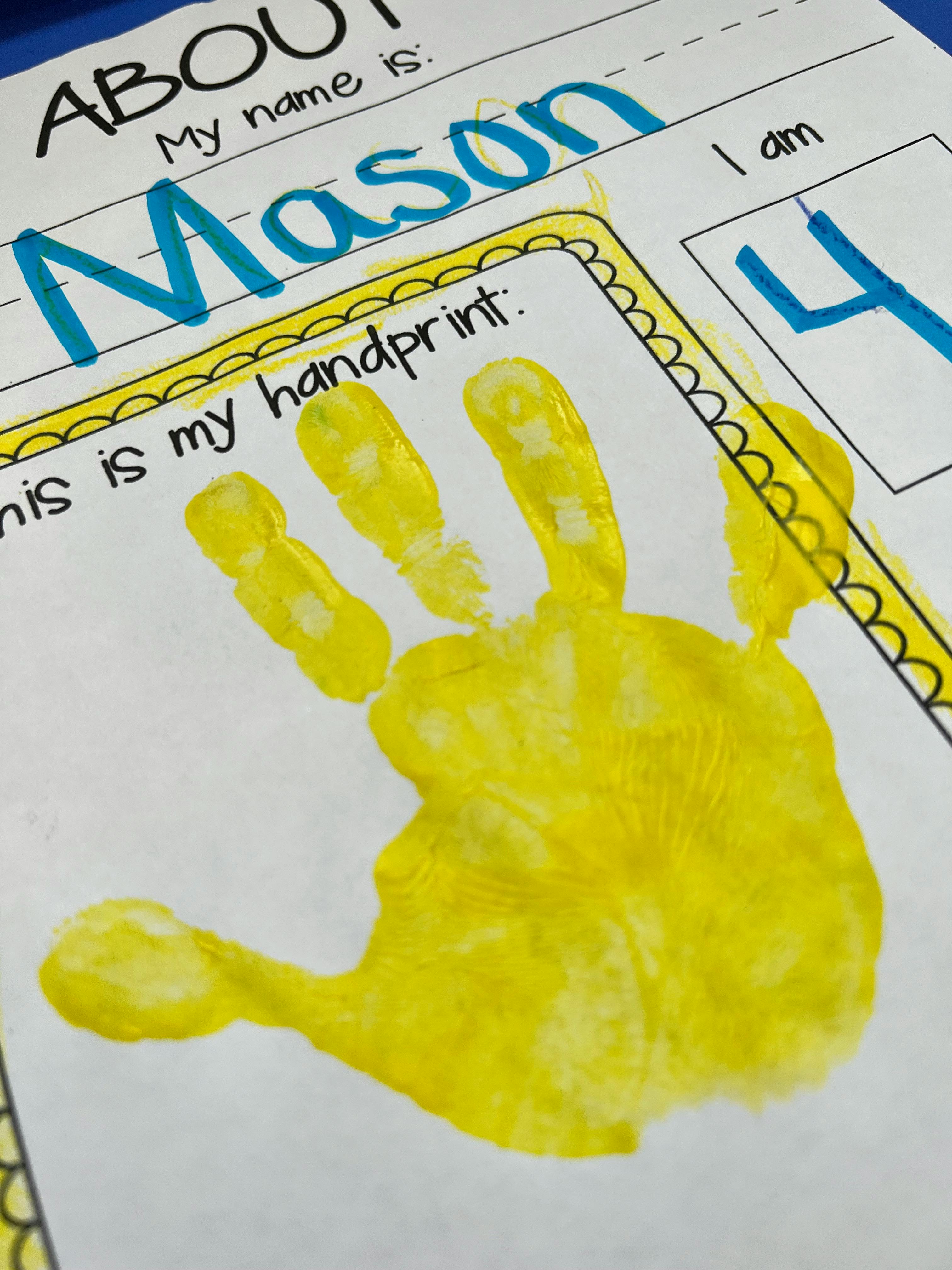 Child's yellow handprint on a paper with text "My name is Mason" and "I am 4"