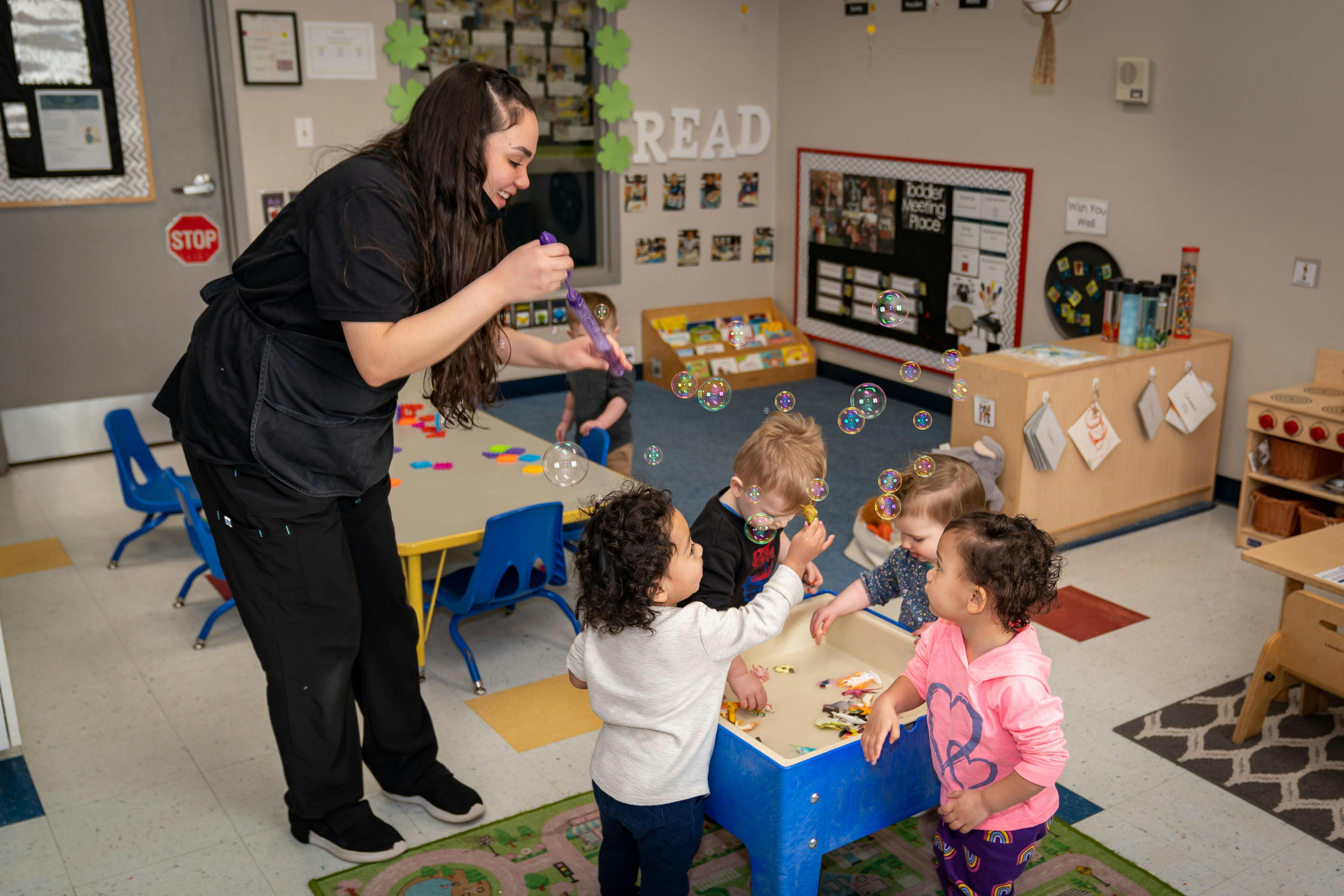 Person blowing bubbles for children in a classroom