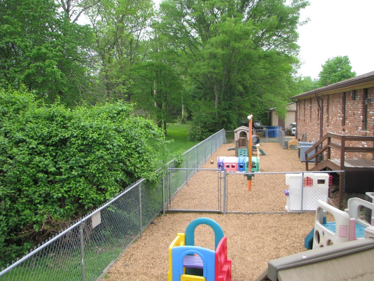 Outdoor playground with colorful equipment and a chain-link fence