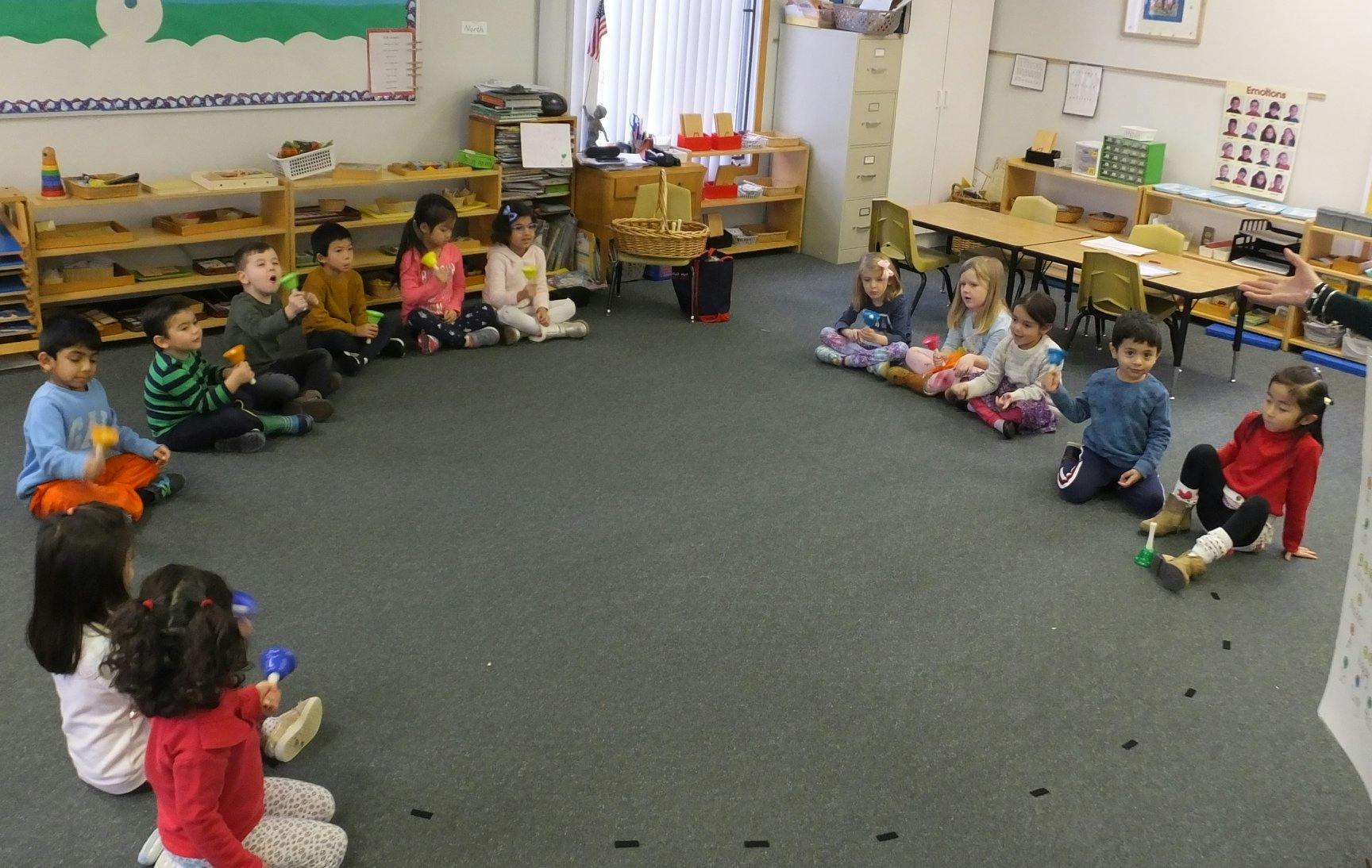 Children sitting in a circle on the floor in a classroom