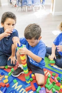Children playing with colorful building blocks on a rug