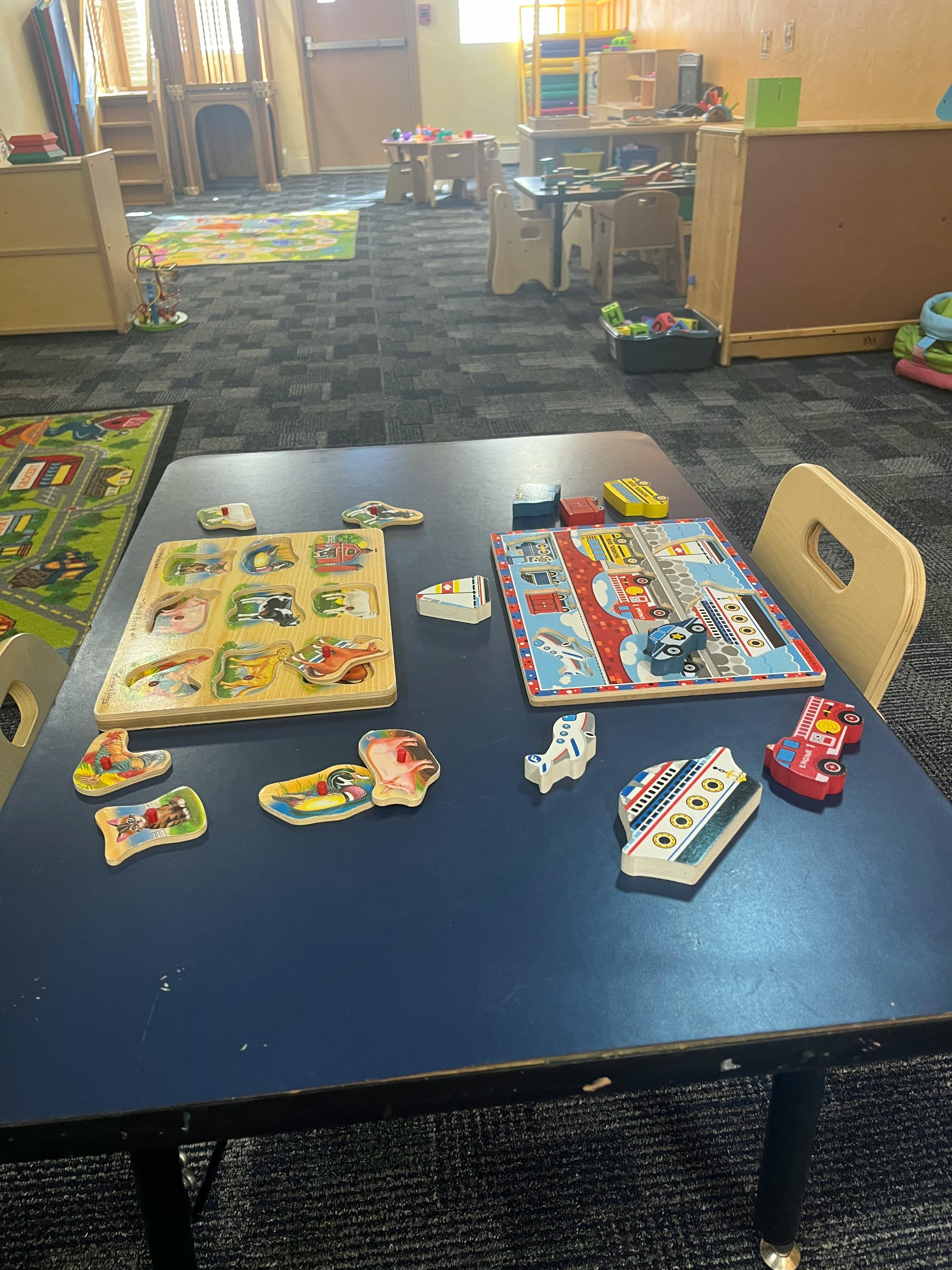 Puzzles and toys on a table in a classroom
