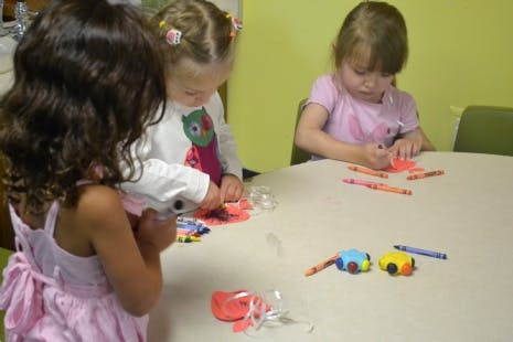 Three children at a table doing crafts