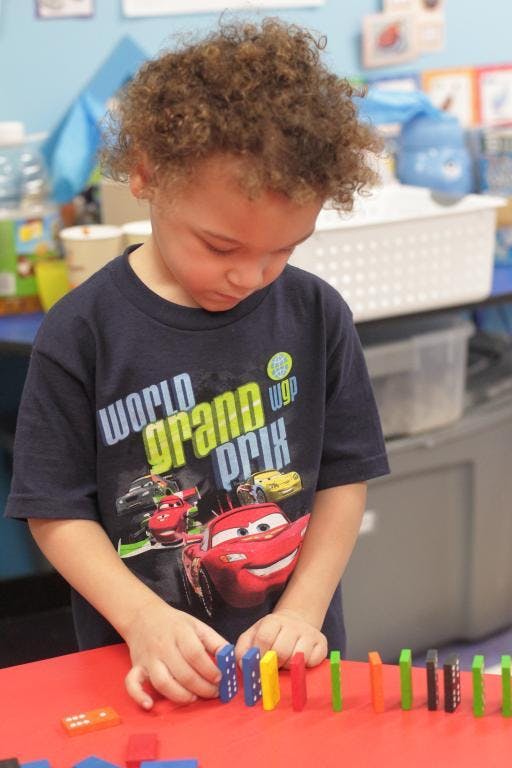 Child playing with colorful dominoes