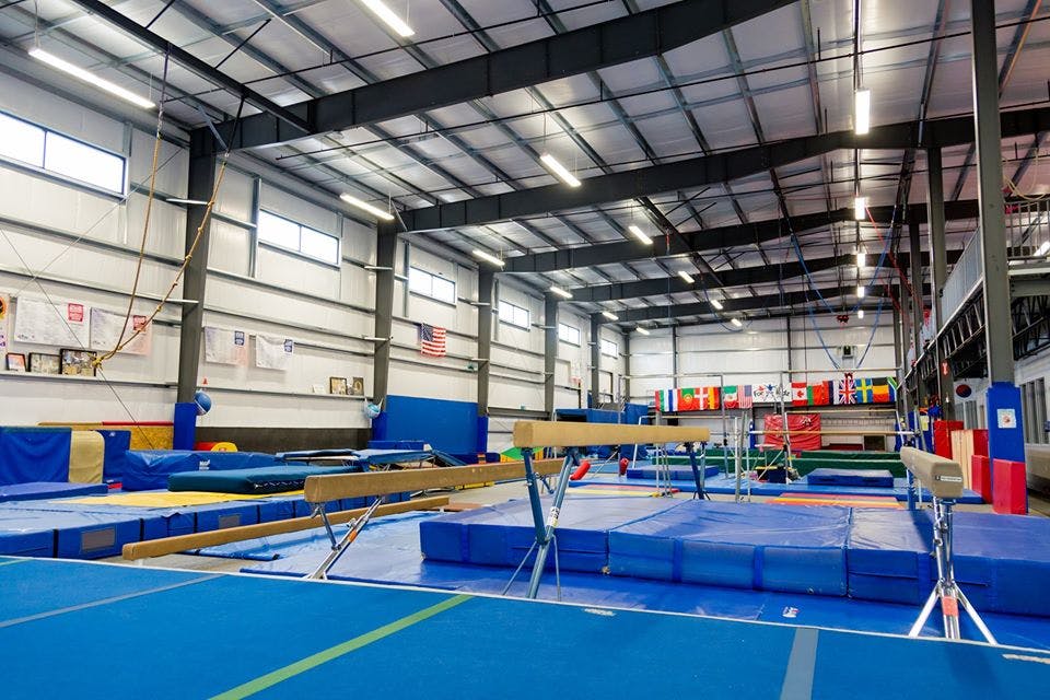 Gymnastics facility with balance beams and blue mats