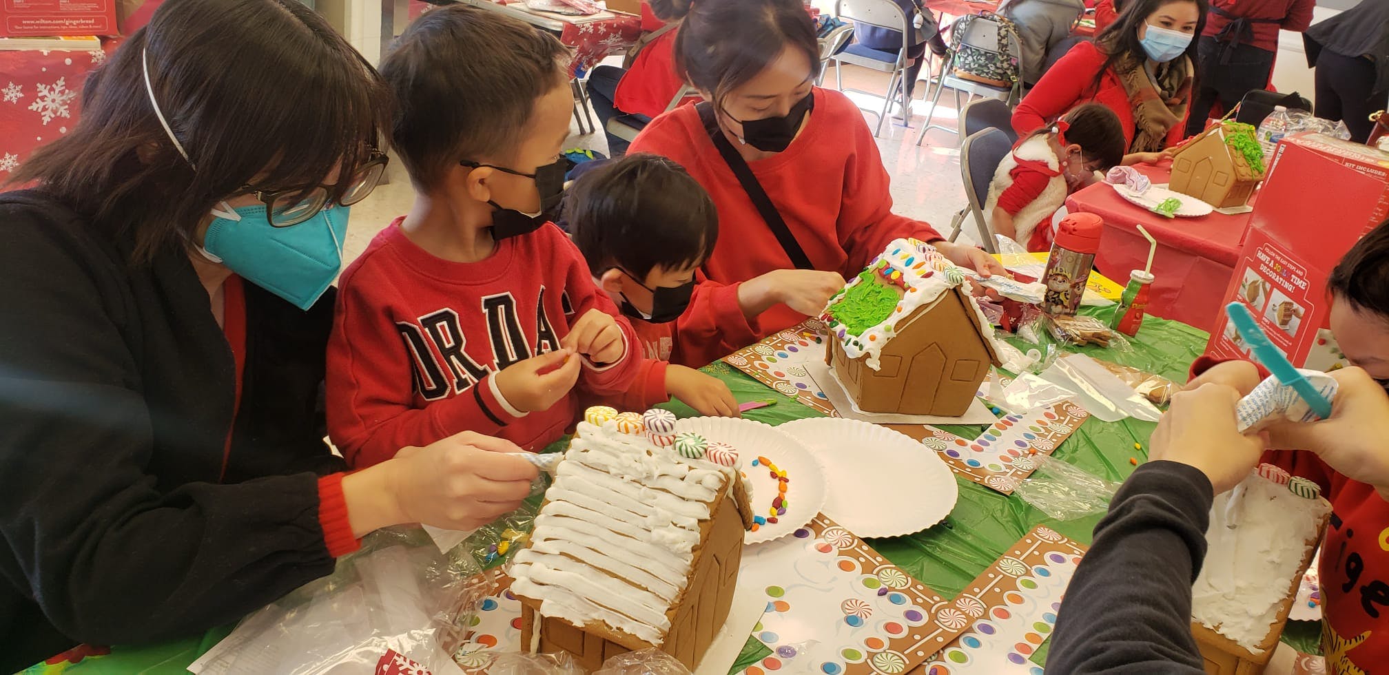 People and children decorating gingerbread houses