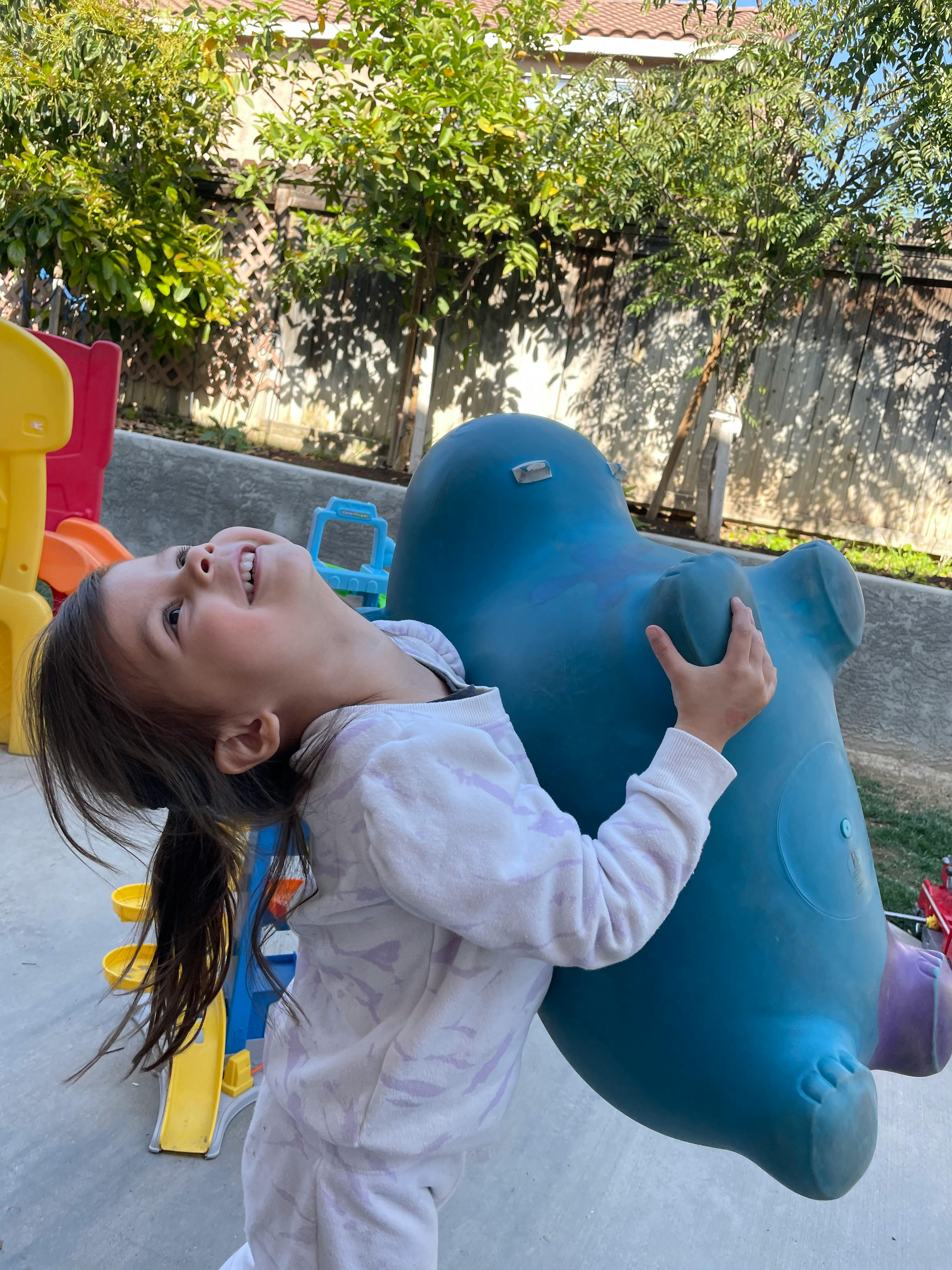 Child playing with a blue plastic toy