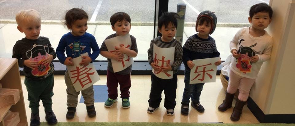 Six children holding signs with Chinese characters