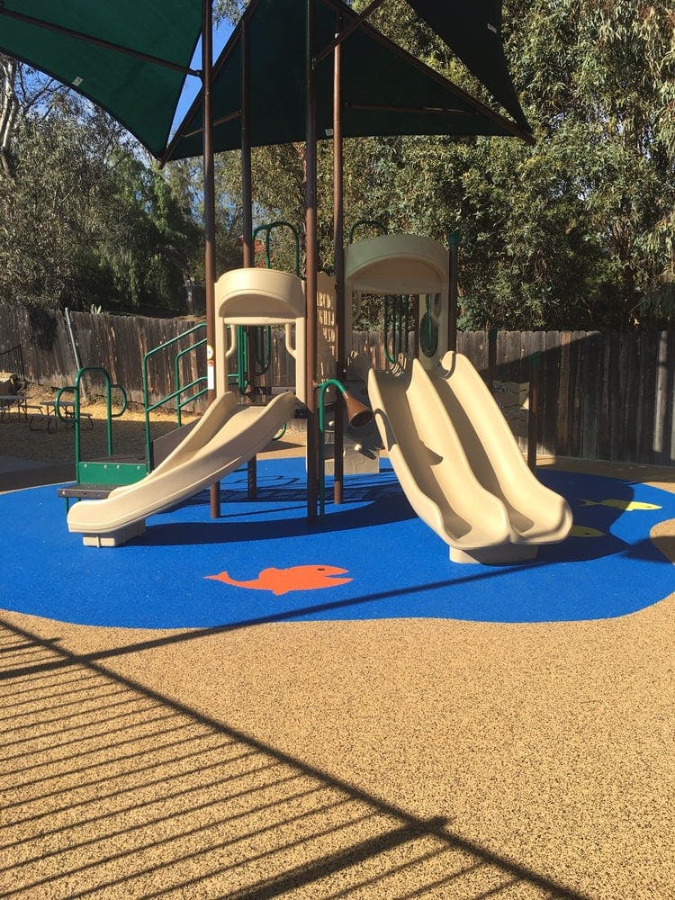 Playground with slides and blue safety surfacing