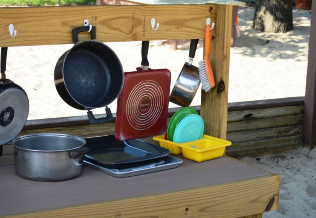 Pots, pans, and dishes on a wooden play kitchen