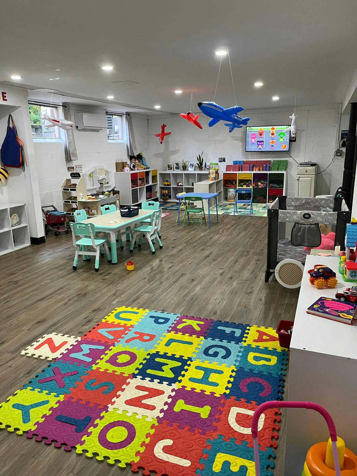 Playroom with furniture and toys on a colorful alphabet floor mat