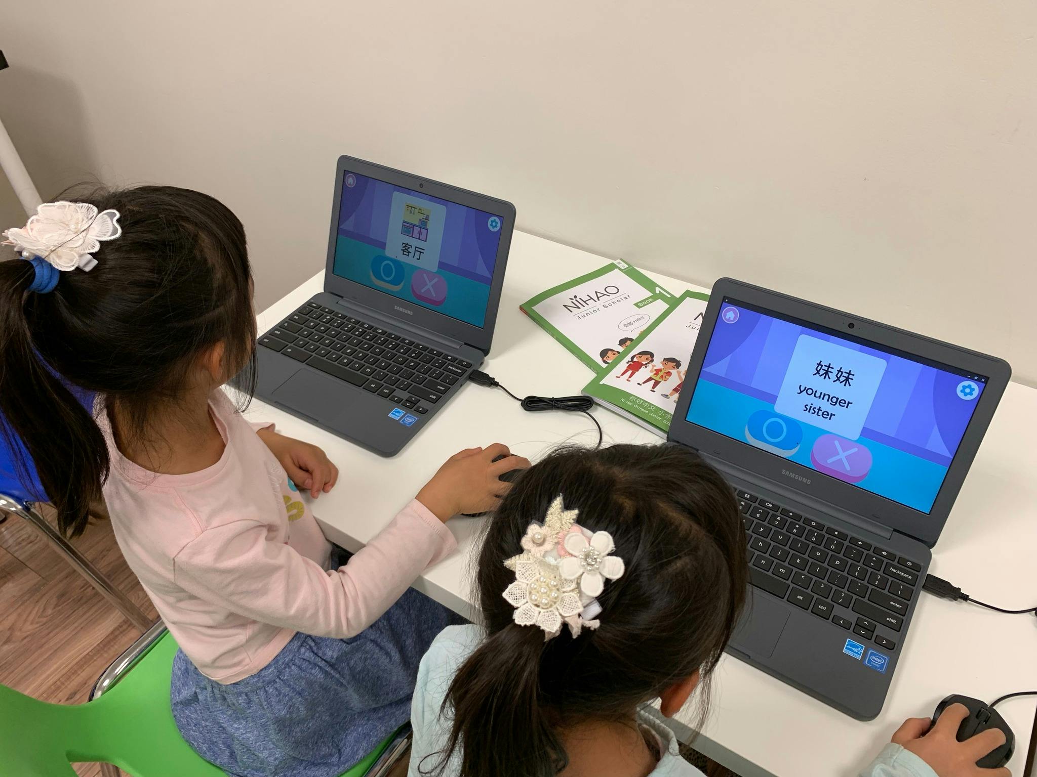 Two children using laptops at a desk