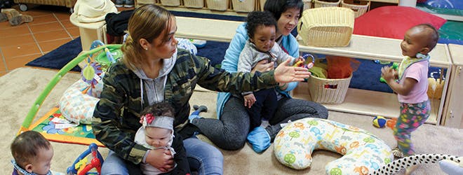 Two people with three children in a play area