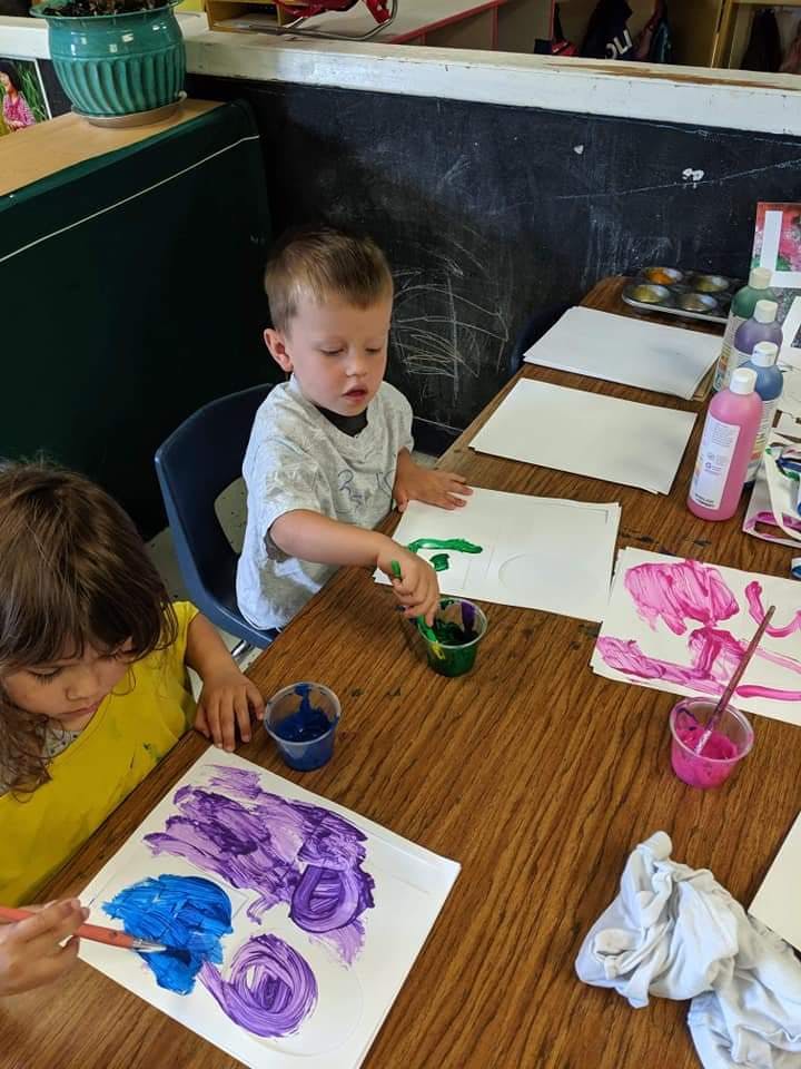 Two children painting at a table