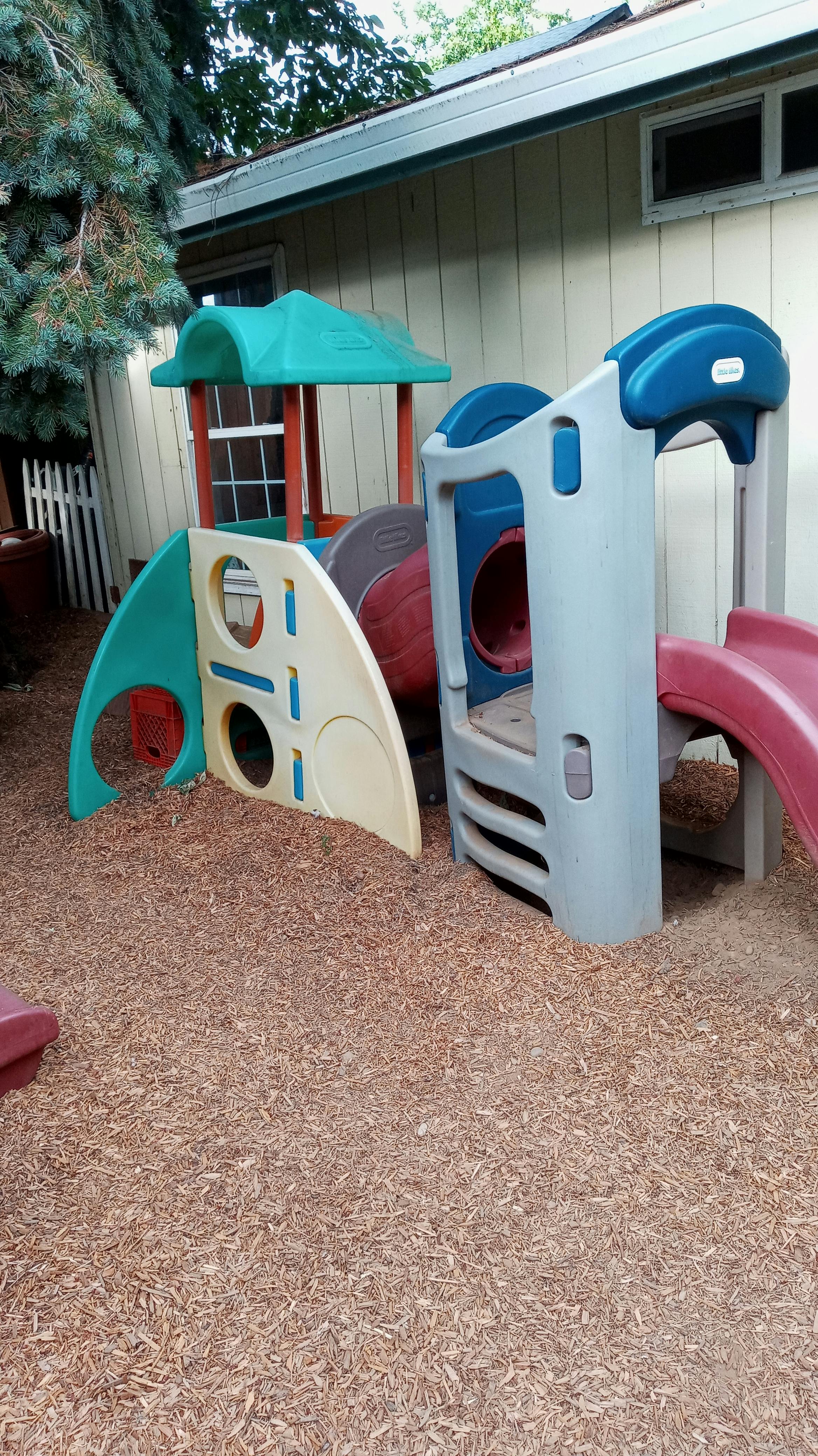 Children's playground equipment with slides and tunnels on wood chips
