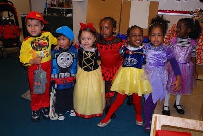Group of children in various costumes standing together