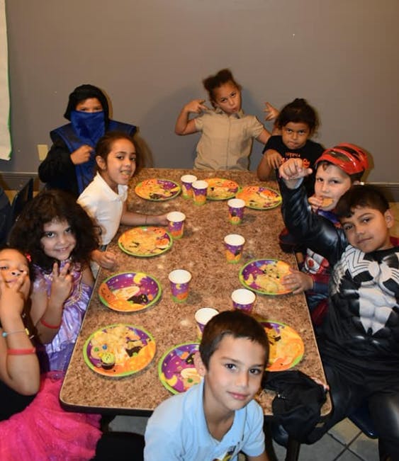 Children sitting around a table with plates and cups