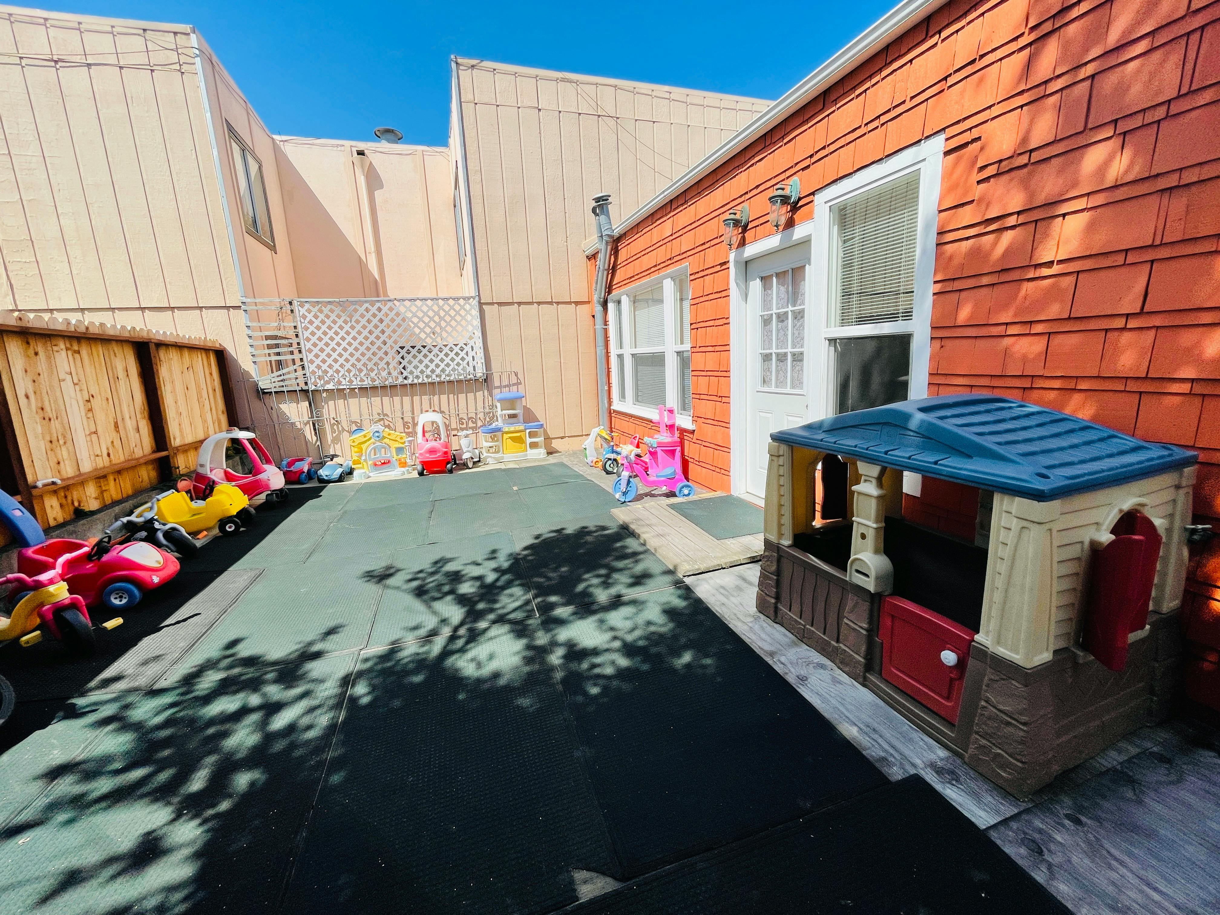 Outdoor play area with toy cars and a playhouse