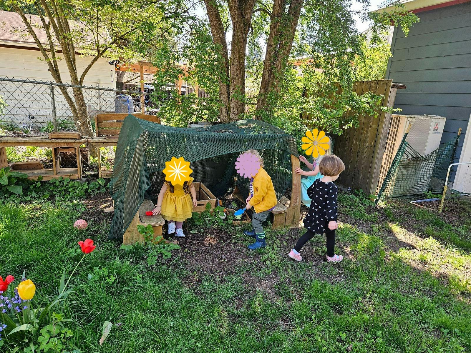 Several children playing outdoors around a covered structure