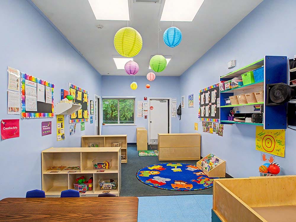 Colorful classroom with toy shelves, rug, and paper lanterns